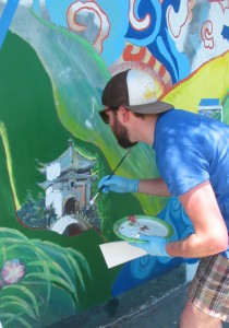 A volunteer repainting a section of the mural